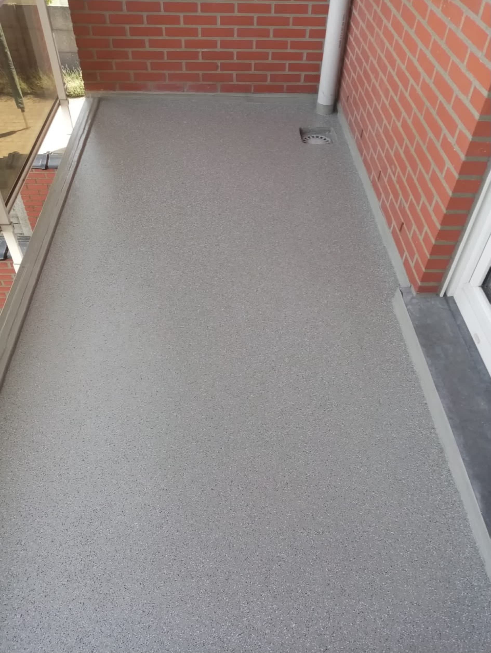 Terras met waterdichte coating tussen bakstenen muren